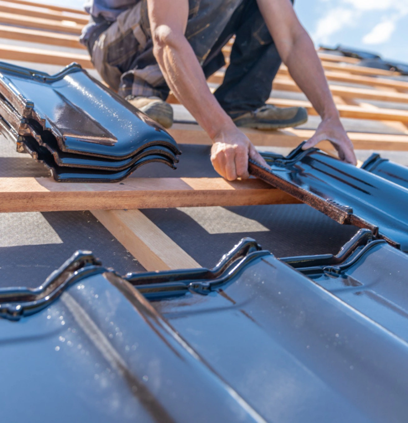 Tile roof installation in Los Angeles with worker placing roof shingles